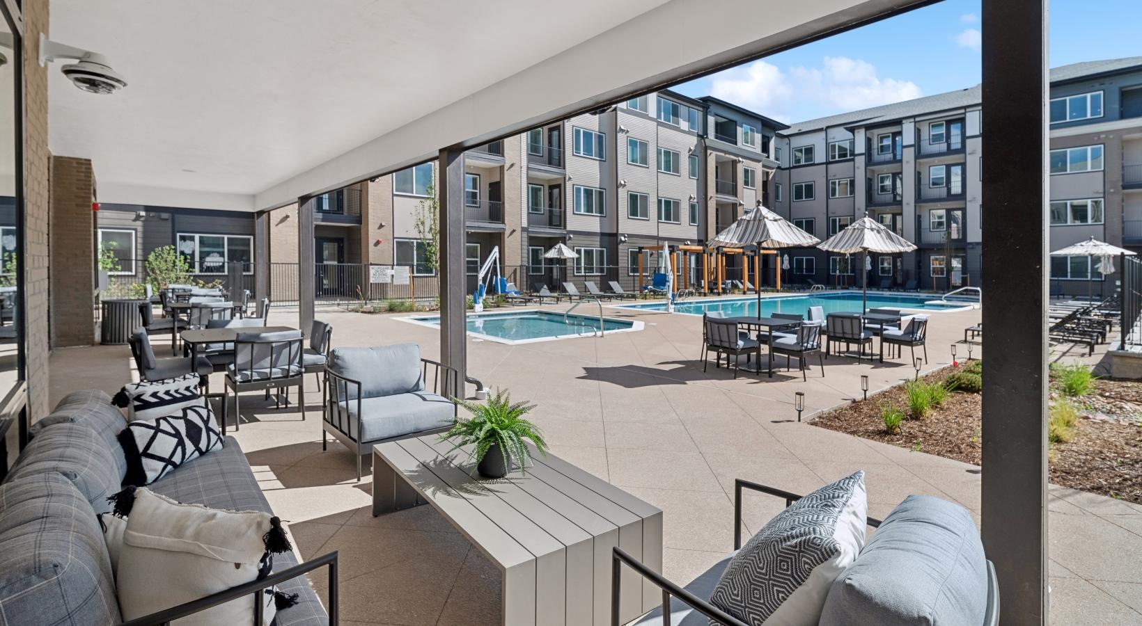 a covered poolside lounge area at Ascend at Pena Station
