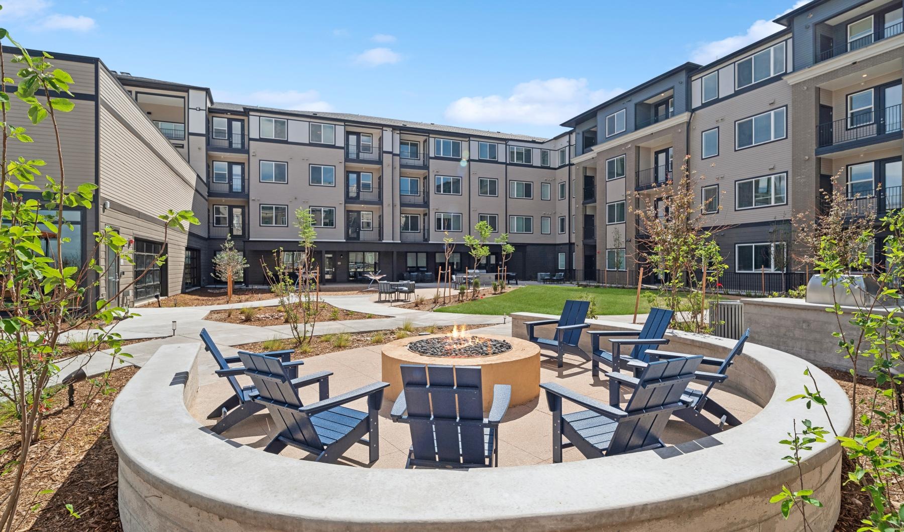 a fire pit with Adirondack chairs at Ascend at Pena Station