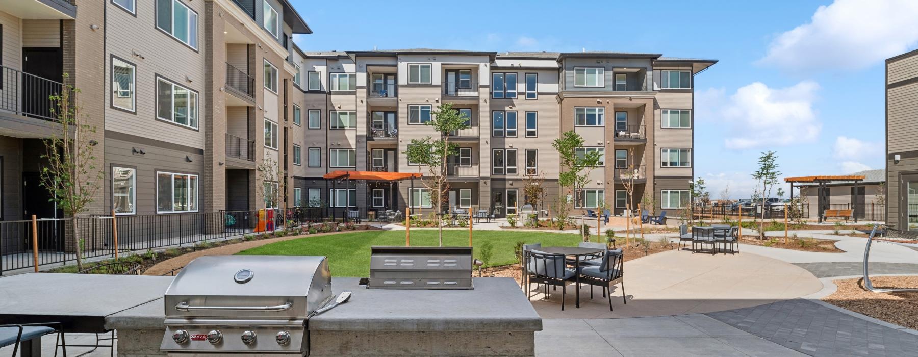 Grilling station and lush landscaping at Ascend at Pena Station